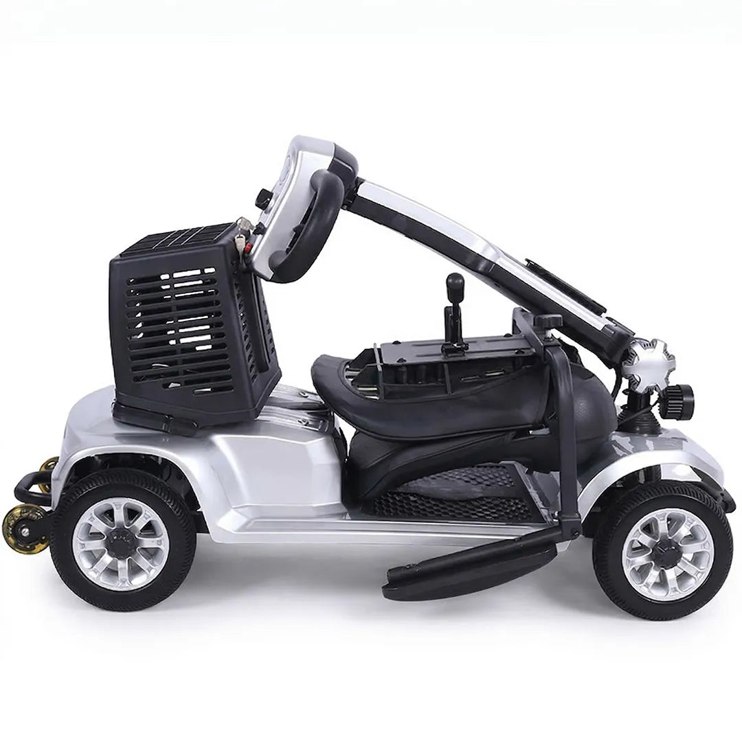 Scooter de movilidad color plata plegado por el mástil sin herramientas y con asiento extraído para guardarlo en el coche dortomedical