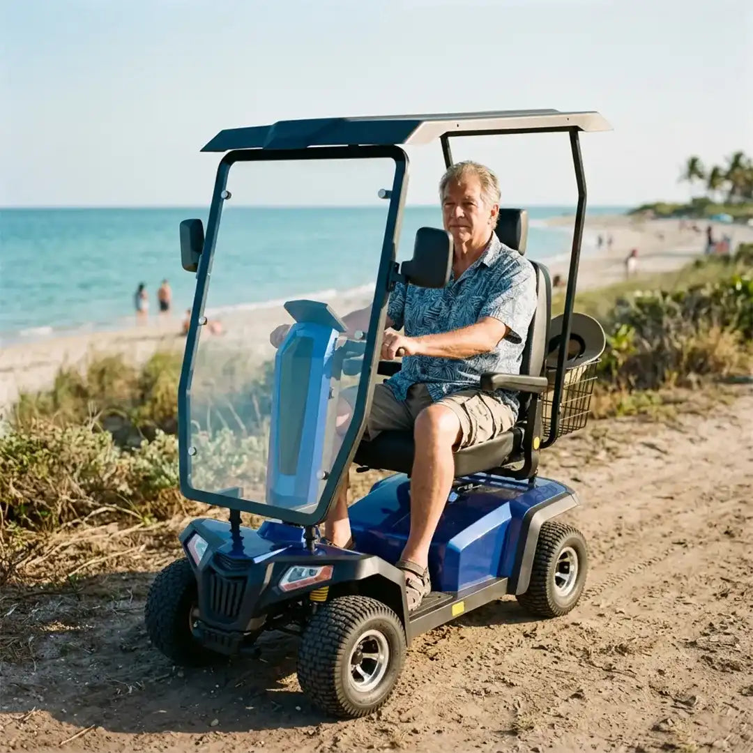 Usuario disfrutando de trayecto en la playa usando el scooter eléctrico todoterreno con batería de 75 Ah para un uso prolongado y mayor autonomía dortomedical