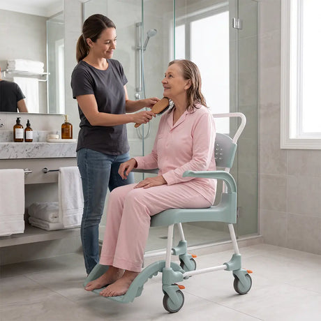 Cuidadora cepillando el pelo de usuaria que utiliza la silla de ducha y WC Etac CLEAN con asiento abierto para facilitar la higiene asistida dortomedical