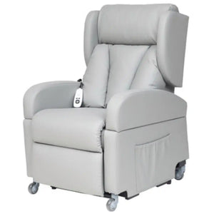 Vista frontal del sillón con el reposabrazos extraído y apoyado en el suelo, mostrando cómo se libera el lateral para realizar transferencias cómodas a sillas de ruedas o camas dortomedical